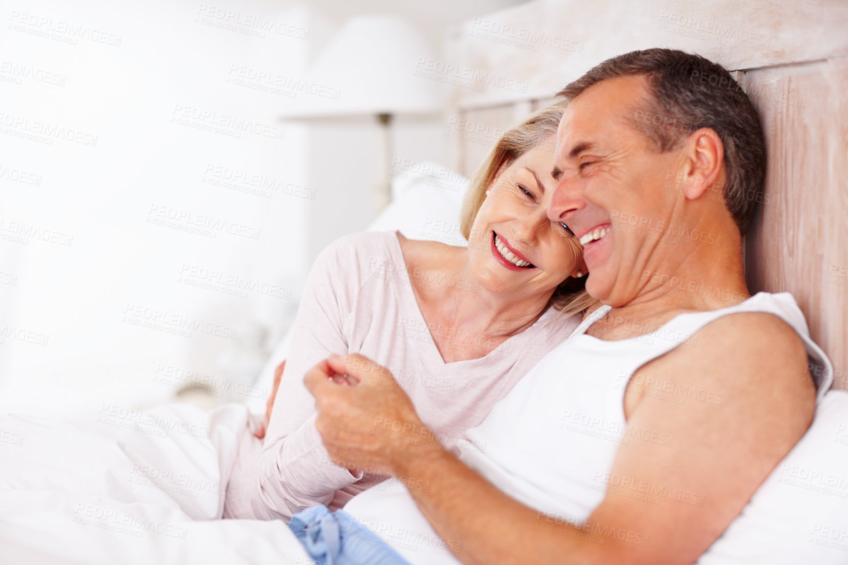 Buy stock photo Mature couple, happy and bonding in bed at house for relax, love and retirement together with trust or care. Man, woman and laughing in hotel bedroom for marriage, loyalty and anniversary on weekend 