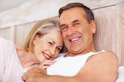 Buy stock photo Mature couple, portrait and hug in bed at house for relax, love and retirement together with trust and care. Man, woman and face in hotel bedroom for marriage, loyalty or tired on weekend with smile