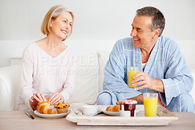 Buy stock photo Mature couple, happy and breakfast together on sofa with bonding, diet nutrition and support in home. Smile, man and woman with morning meal, healthy food and romantic time for love relationship