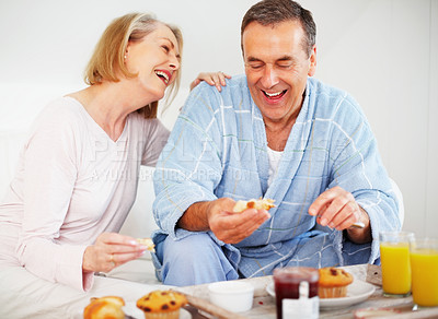 Buy stock photo Mature couple, bedroom and food for care, breakfast and nutrition for retirement health. Senior woman, man and croissant or muffin with fruit jam for diet, romance and elderly wellness or support