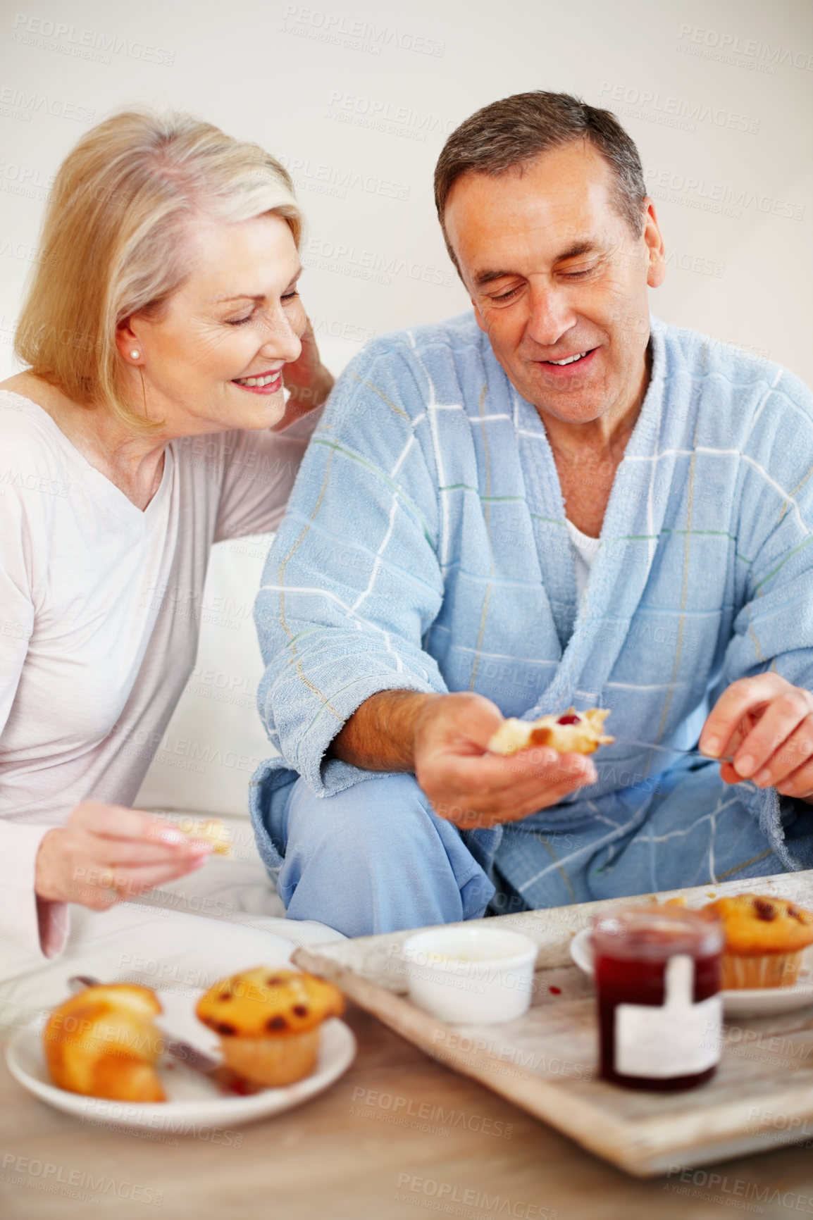 Buy stock photo Mature couple, bedroom and food for breakfast, support and nutrition for retirement health. Senior woman, man and croissant or muffin with fruit jam for diet, romance and elderly wellness or hotel