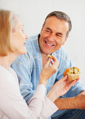 Buy stock photo Mature couple, bedroom and food for morning, breakfast and nutrition for retirement health. Senior woman, man and croissant or muffin with baked good for diet, romance and elderly wellness or care