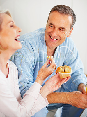 Buy stock photo Senior couple, bedroom and food for morning, breakfast and nutrition for retirement health. Mature woman, man and croissant or muffin with baked good for diet, romance and elderly wellness or home