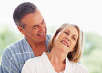 Happy mature man looking at wife against colored background