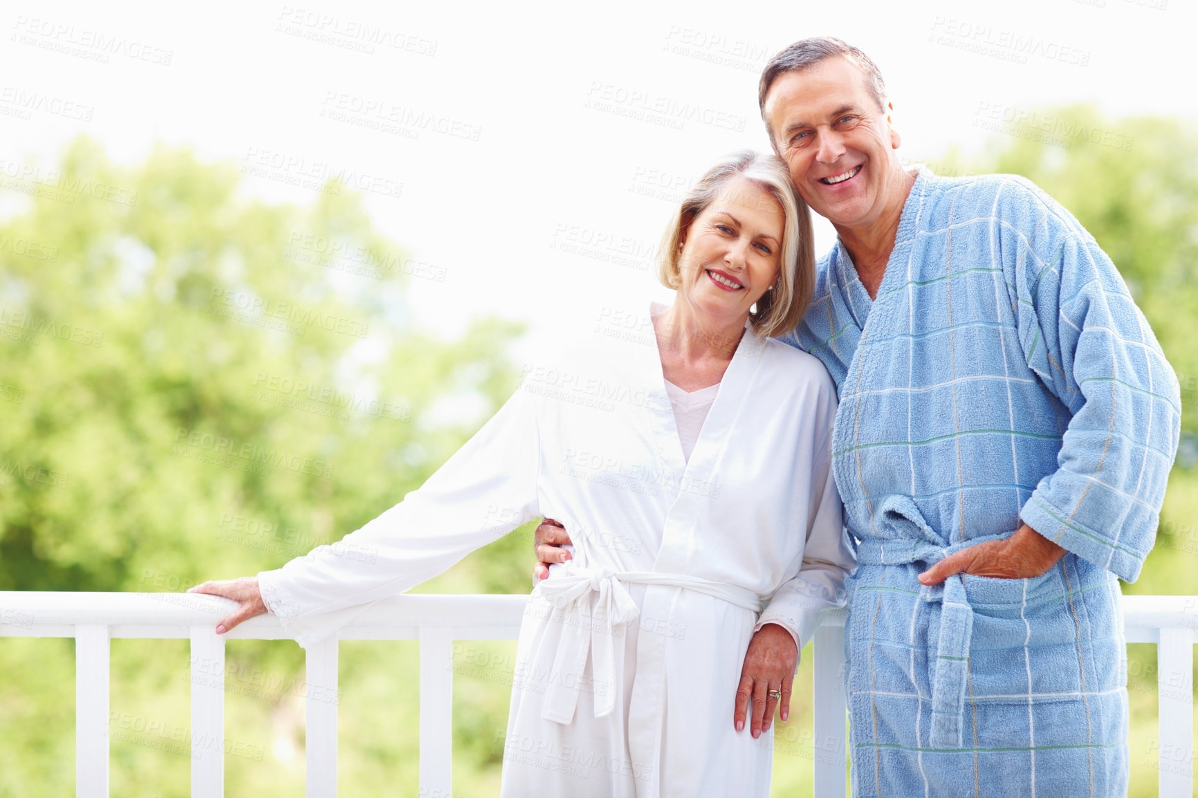 Buy stock photo Portrait, hug and bathrobe with mature couple, love and support on balcony of house together. Smile, face and trust with happy, senior man and woman bonding while enjoying retirement at home