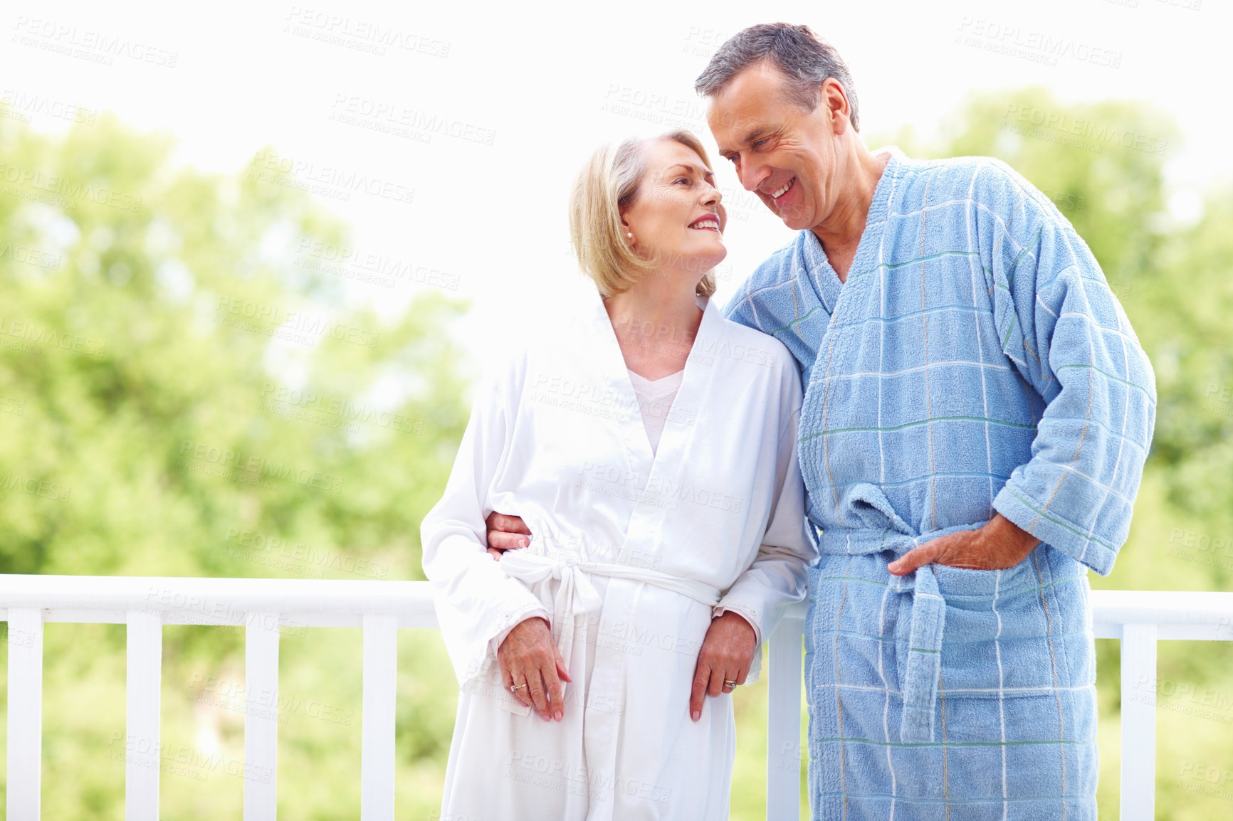 Buy stock photo Senior, couple and bathrobe outdoor on holiday for anniversary trip, romantic vacation and hug on balcony. Elderly, people and embrace for bonding on honeymoon retreat, resort and relax with smile