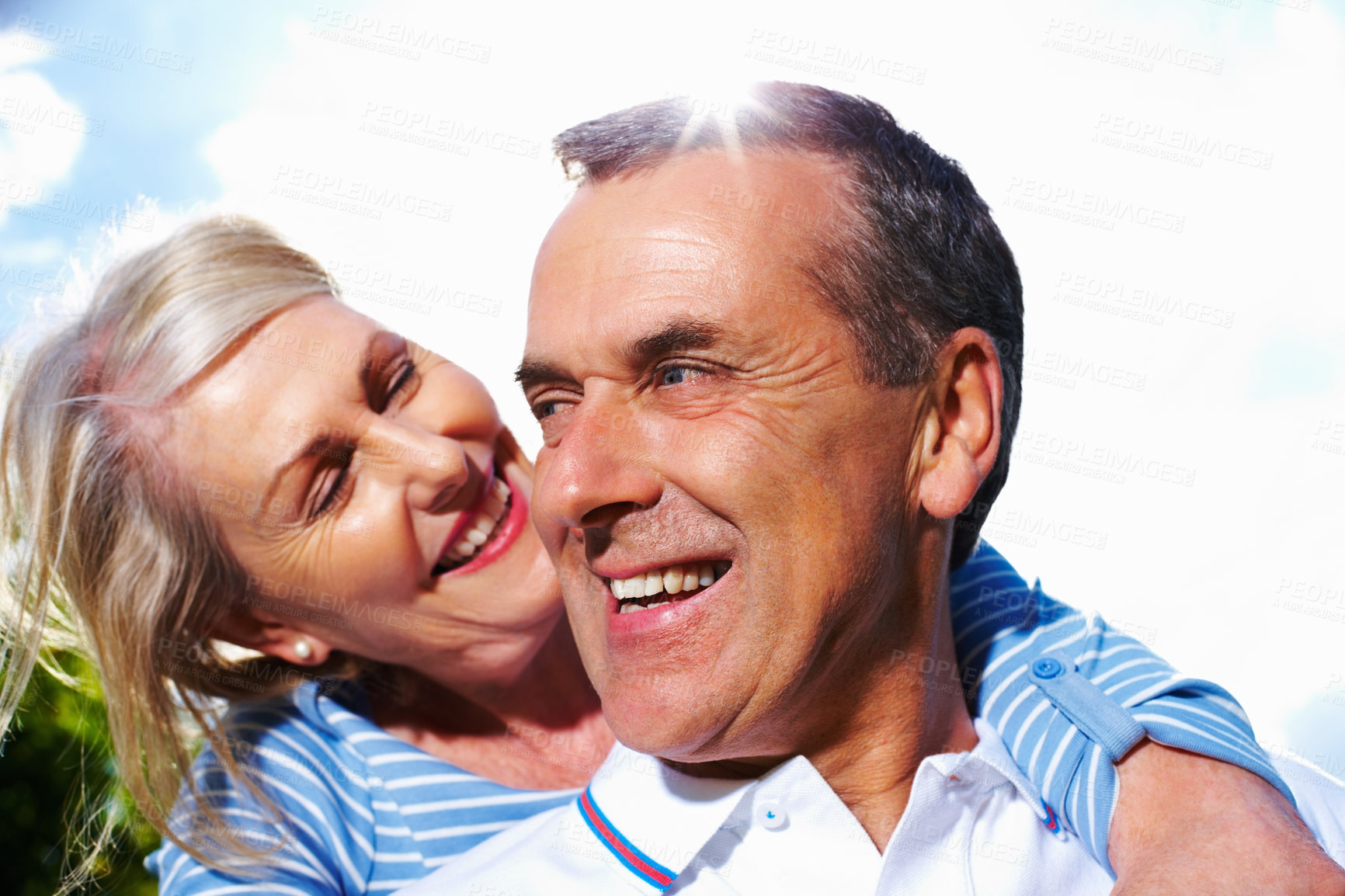 Buy stock photo Mature, happy couple and hug with blue sky in sunshine for love, support or care together in nature. Senior man and woman with smile in embrace for outdoor romance, bonding or holiday weekend at park