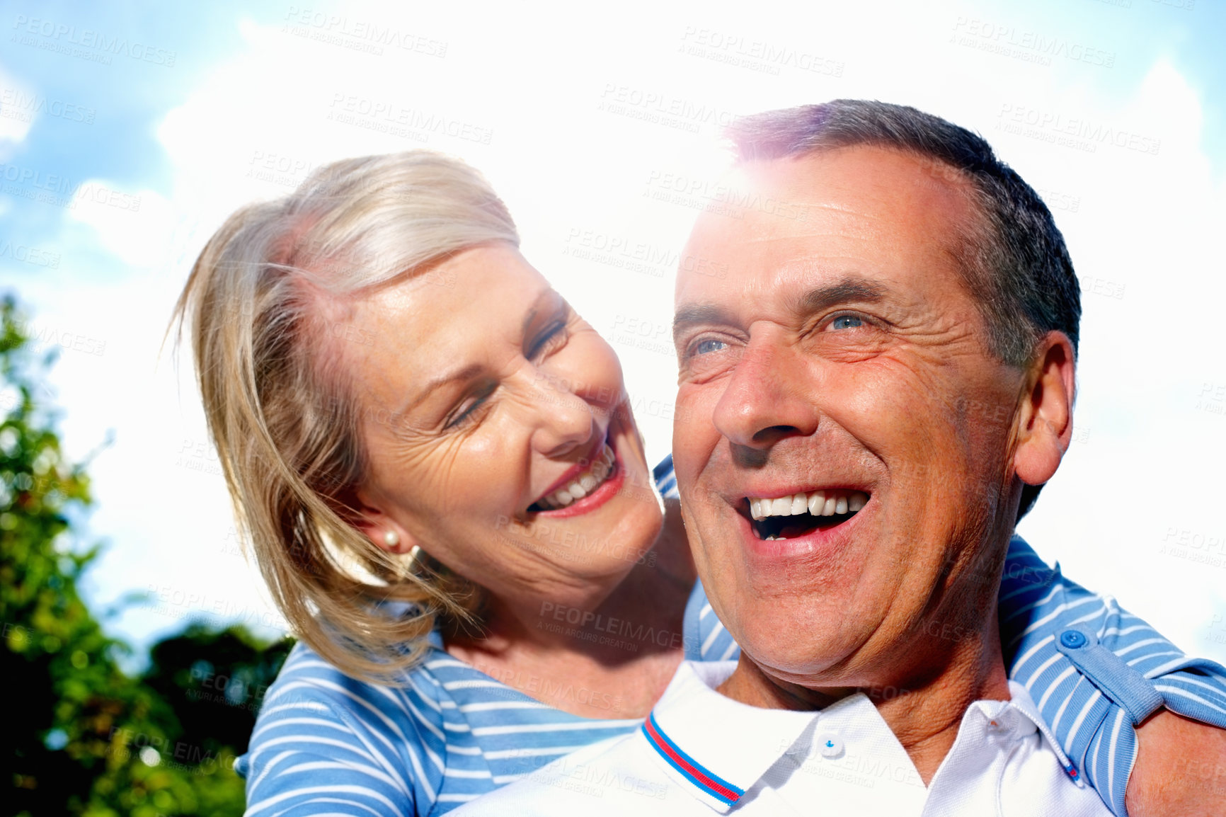 Buy stock photo Senior, happy couple and hug with blue sky in sunshine for love, support or care together in nature. Mature man and woman with smile in embrace for outdoor romance, bonding or holiday weekend at park