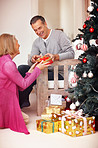 Mature woman gifting her husband on Christmas festival