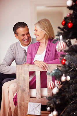 Buy stock photo Senior, happy couple and christmas tree with love or support for festive celebration at home. Mature man and woman with smile or hug in joy or embrace on December holiday or weekend together at house