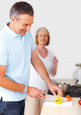 Buy stock photo Cutting vegetables, home and senior couple with love, skills and happiness with romance, lunch and nutrition. Apartment, woman and man with knife, diet and healthy food with anniversary meal and joy