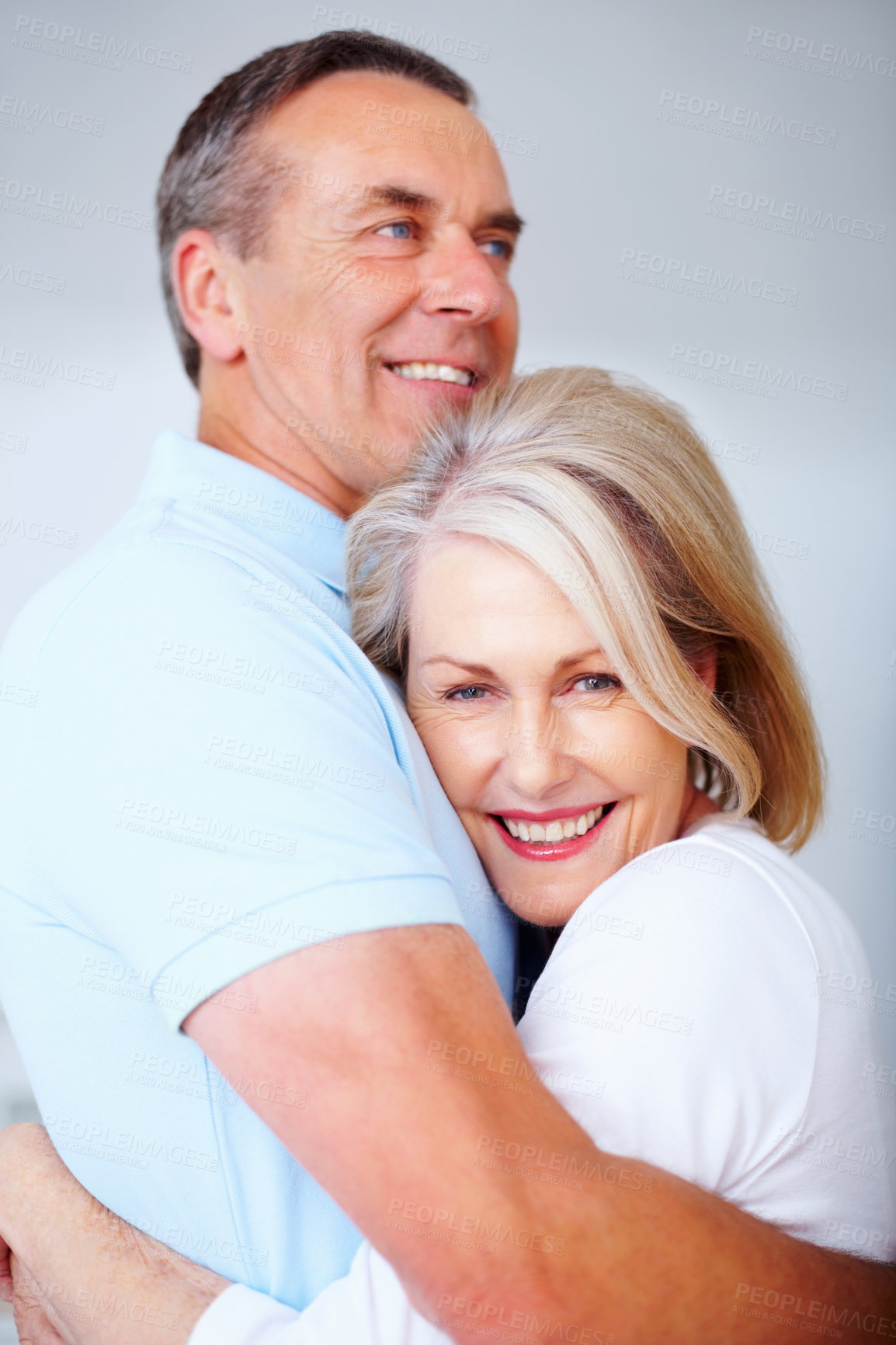 Buy stock photo Senior couple, happy and portrait in gray background in love, hug or embrace as romantic partner. Woman, man and affection for bonding, relationship and together in studio backdrop for health or care