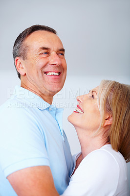 Buy stock photo Mature couple, happy and laugh in gray background for love, hug OR embrace as romantic partner. Woman, man and affection for bonding, relationship and together in studio backdrop for health or care
