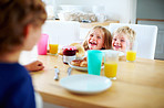 Cheerful young kids having fun during their breakfast