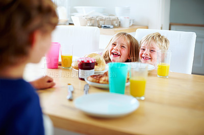 Buy stock photo Children, breakfast and laughing at home in the morning with food, smile and happy from eating. Family, dinner table and hungry young child with meal for health and nutrition in a house with juice