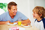 Cheerful father and son together having breakfast