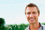 Closeup of a handsome male smiling against sky