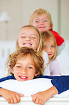 Smiling brothers and sisters having fun together in bed