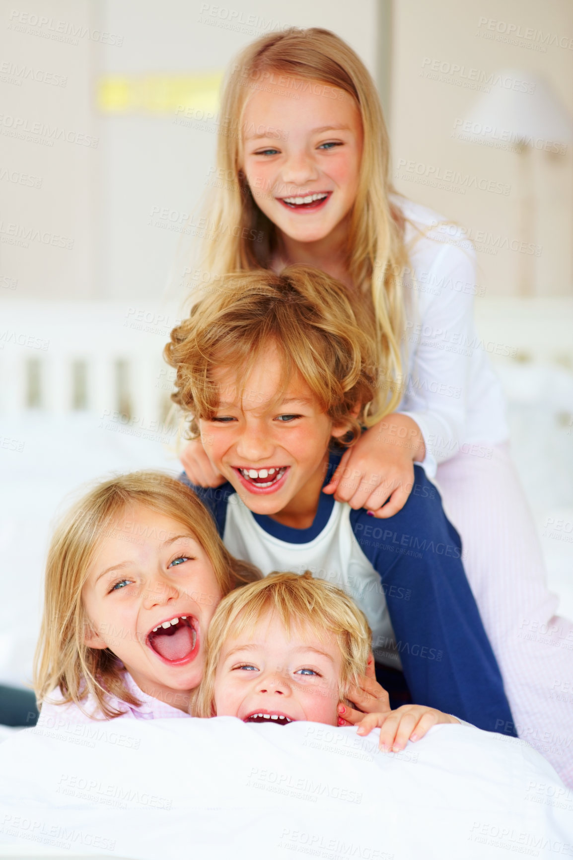 Buy stock photo Portrait, laughing or crazy with brother and sister sibling children on a bed in their home together. Family, funny or silly with young boy and girl kids in the bedroom of an apartment on the weekend