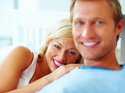 Buy stock photo Portrait, couple and smile in bed of home for love, care and relax on holiday, rest or wake up together. Face, woman or bond with man in happy relationship, freedom or romantic anniversary in bedroom