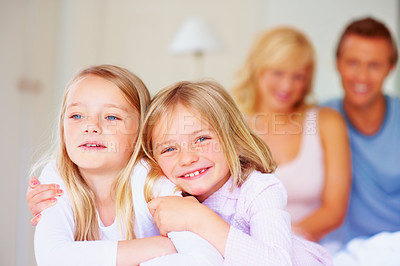 Buy stock photo Portrait, siblings or sisters for hug together on bed, relax wellness and happiness with care support in home. Girls, embrace and smile face for bonding with proud parents and morning love in house