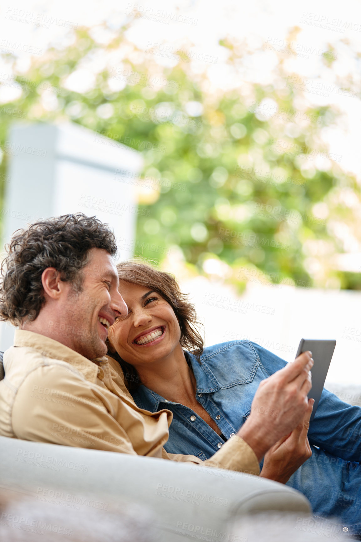 Buy stock photo Shot of a husband and wife using a digital tablet together at home