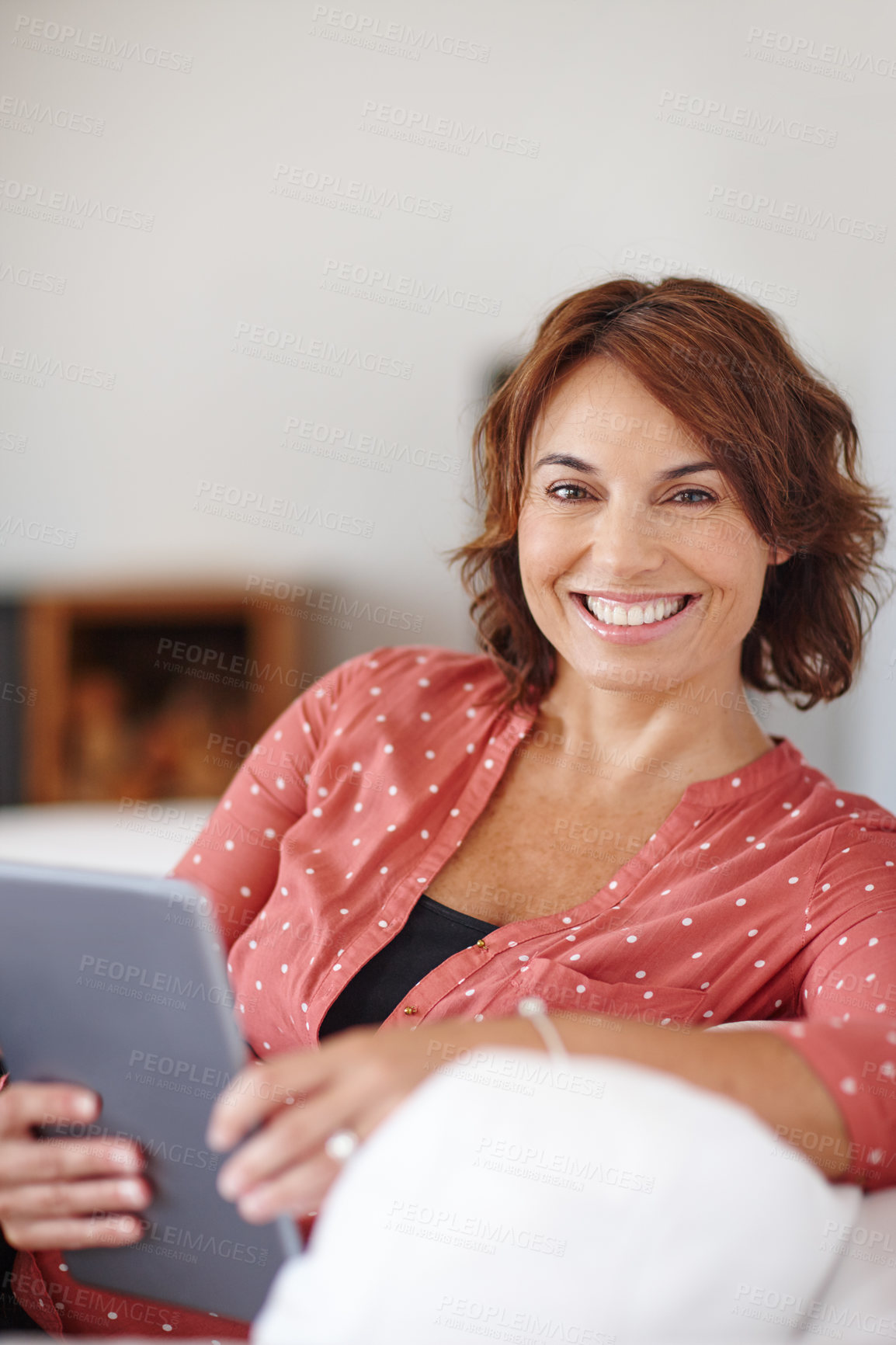 Buy stock photo Shot of a mature woman using a digital tablet on the sofa at home