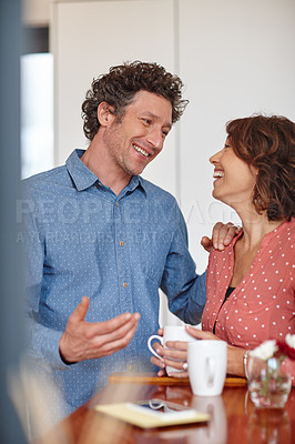 Buy stock photo Shot of a happy husband and wife having a conversation at home