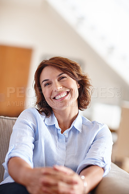 Buy stock photo Shot of a mature woman sitting on her sofa at home