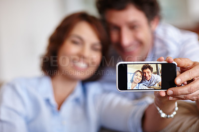 Buy stock photo Cropped shot of a husband and wife taking a selfie together at home