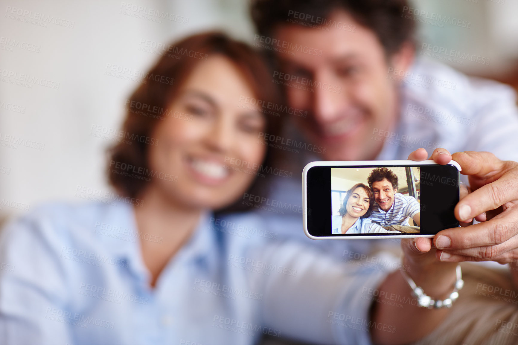 Buy stock photo Cropped shot of a husband and wife taking a selfie together at home