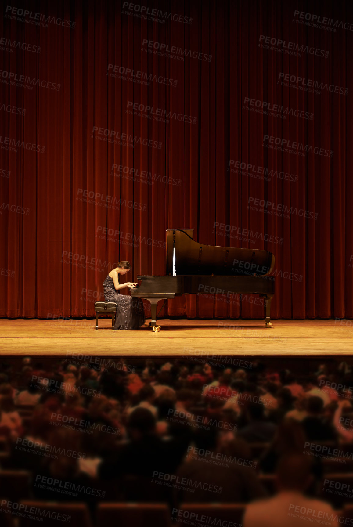 Buy stock photo Shot of a young woman playing the piano during a musical concert