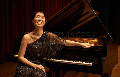 Buy stock photo Shot of a young woman sitting by her piano at the end of a musical concert