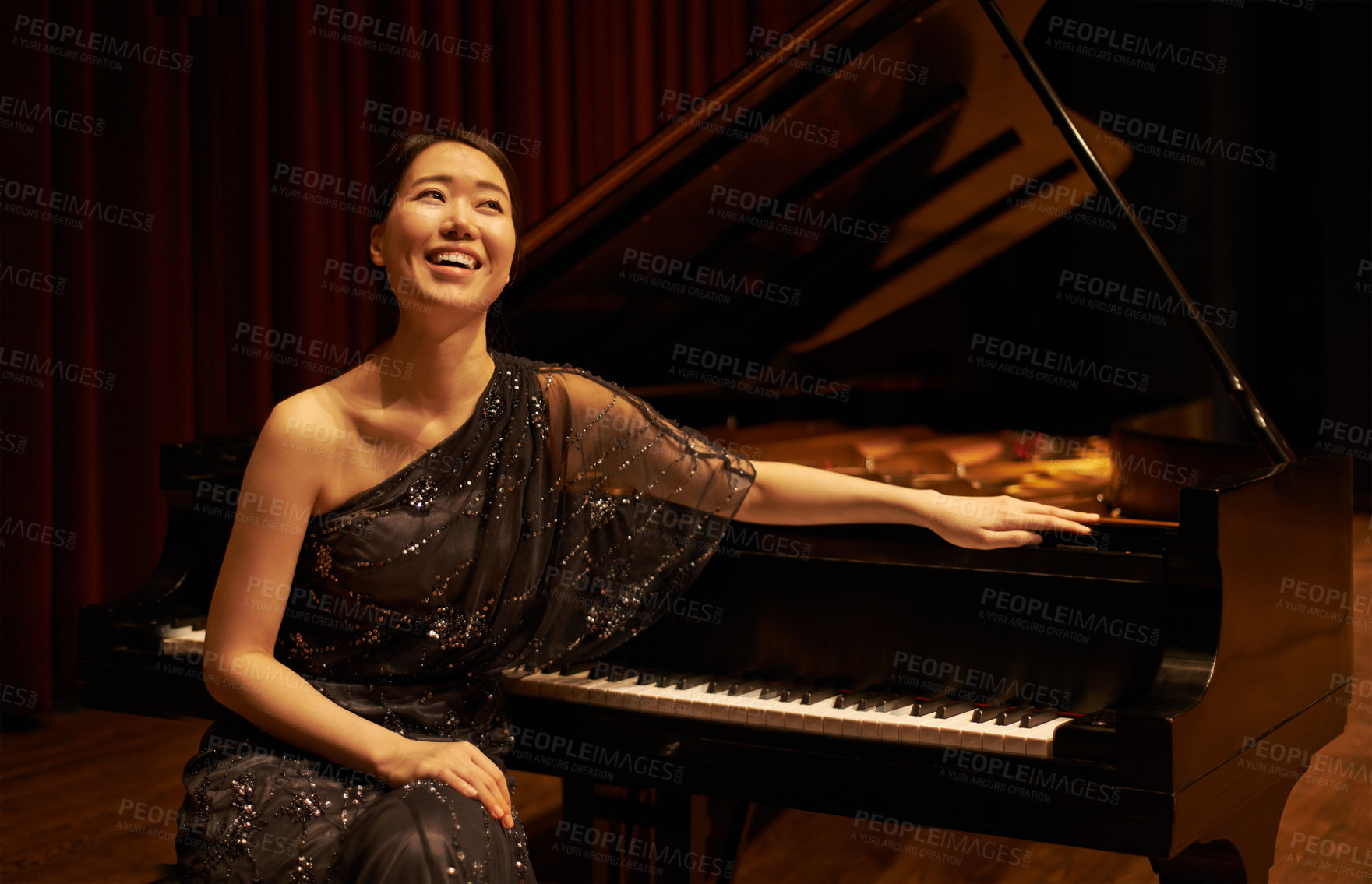 Buy stock photo Shot of a young woman sitting by her piano at the end of a musical concert