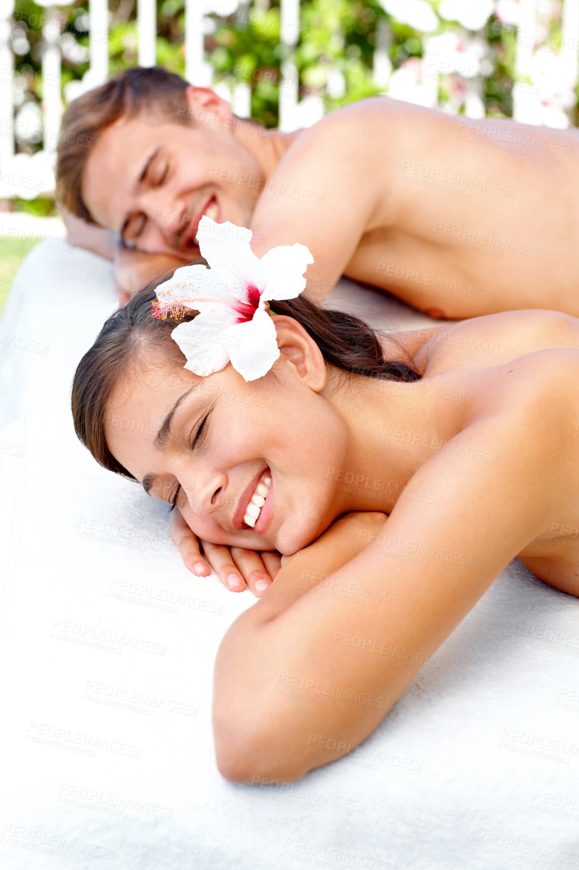 Buy stock photo Massage, relax and happy couple at spa in nature for skincare, health and wellness on table. Beauty, man and woman at luxury salon with hibiscus flower outdoor for natural and holistic on holiday