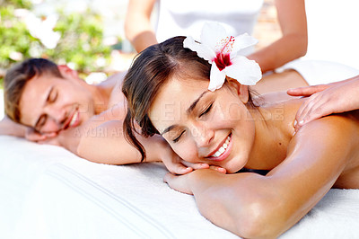 Buy stock photo Back massage, relax and happy couple at spa outdoor for skincare, health and wellness on table. Masseuse, man and woman at luxury salon with hibiscus flower in nature for beauty therapy on holiday