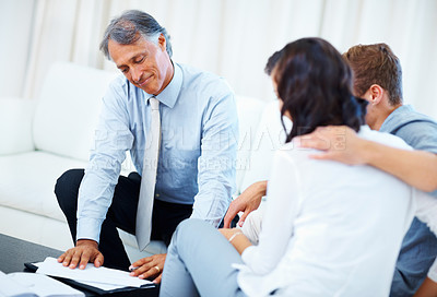Buy stock photo Mature financial planner explaining financial plan with young couple at home