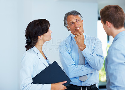 Buy stock photo Portrait of mature business man listening carefully to colleague with woman in office