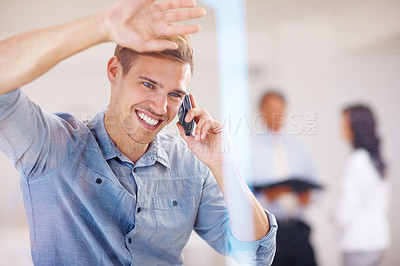 Buy stock photo Portrait of smiling young man looking out through glass while talking on cellphone