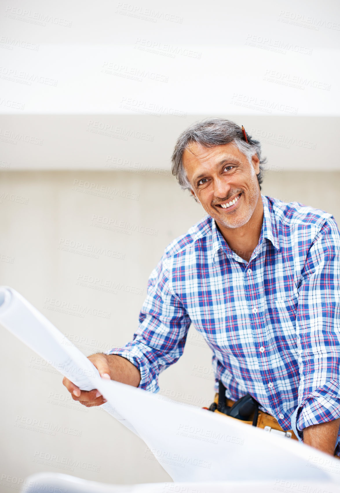 Buy stock photo Portrait of handsome mature architect smiling with blueprint in hand