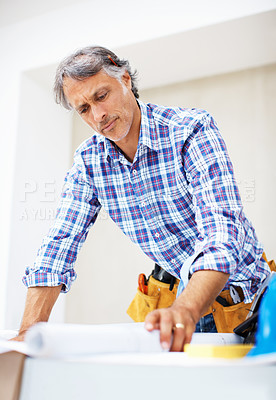 Buy stock photo Busy mature engineer working on construction plan