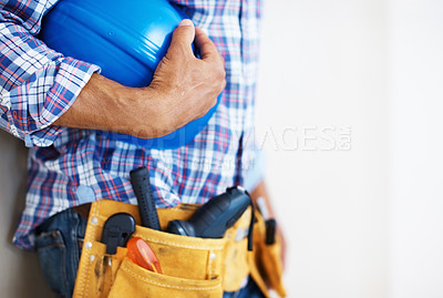 Buy stock photo Mid section of construction worker with tool belt holding blue protective helmet