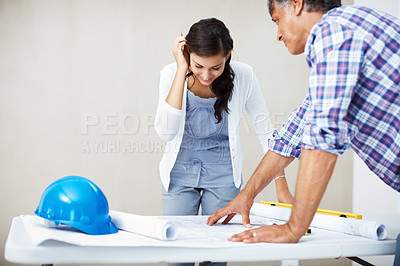Buy stock photo Happy young woman smiling while discussing home renovation plans with architect over blueprint