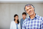 Mature architect with couple in background