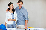 Attractive couple smiling with blueprint