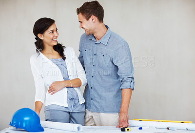 Buy stock photo Cheerful young couple smiling while discussing house plan