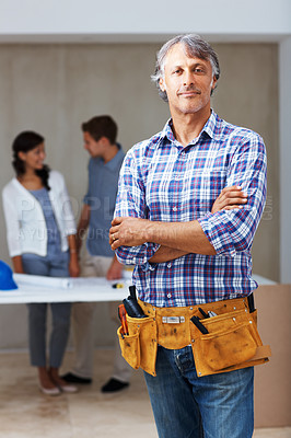Buy stock photo Portrait of confident male contractor standing with clients discussing in background