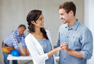 Buy stock photo Beautiful happy couple holding hands with architect in background