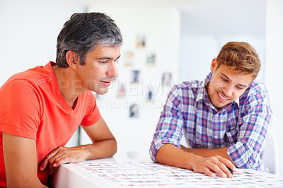 Buy stock photo Two male photographers sitting at table and discussing about the photos