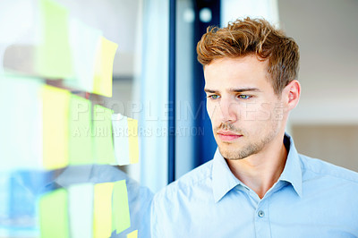 Buy stock photo Thoughtful business man looking at adhesive notes on glass